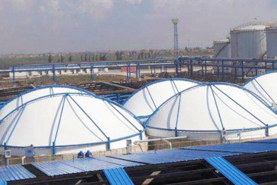 Covered sludge tanks at a wastewater treatment plant for odor control